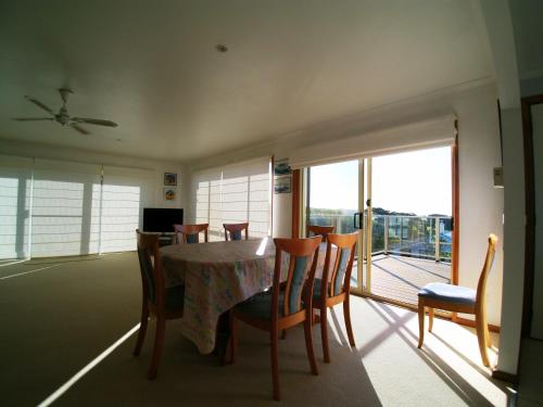 
a dining room table with chairs and a window at 3 Bay Lane in Kianga
