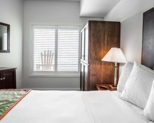 a bedroom with a white bed and a window at Island Inn & Suites, an Ascend Collection Hotel in Piney Point