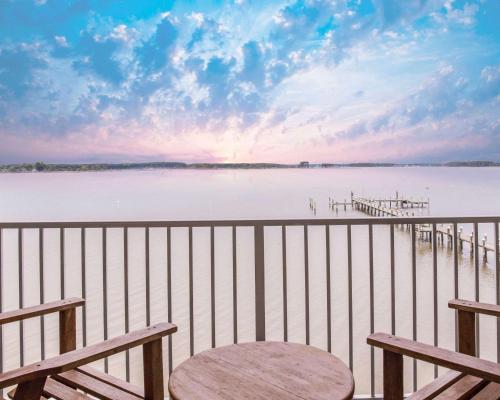 a view of the water from a balcony with benches at Island Inn & Suites, an Ascend Collection Hotel in Piney Point
