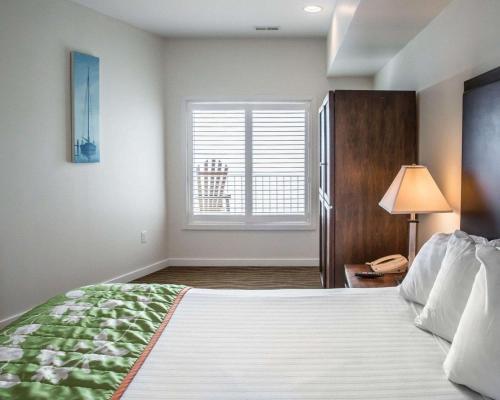 a bedroom with a large bed and a window at Island Inn & Suites, an Ascend Collection Hotel in Piney Point