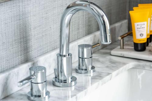a kitchen sink with a faucet and three cups at Edgar Hotel Martha's Vineyard, an Ascend Collection Hotel in Edgartown