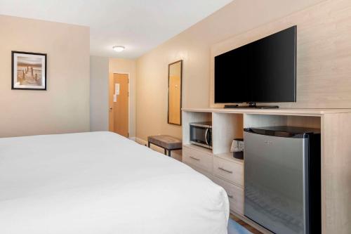 a bedroom with a bed and a flat screen tv at Casco Bay Hotel Portland Airport - Maine Mall, an Ascend Collection Hotel in South Portland