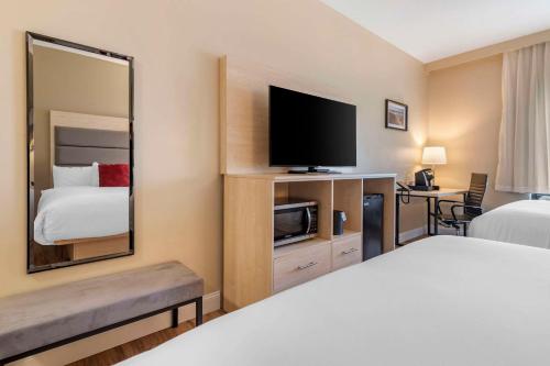 a hotel room with a bed and a flat screen tv at Casco Bay Hotel Portland Airport - Maine Mall, an Ascend Collection Hotel in South Portland