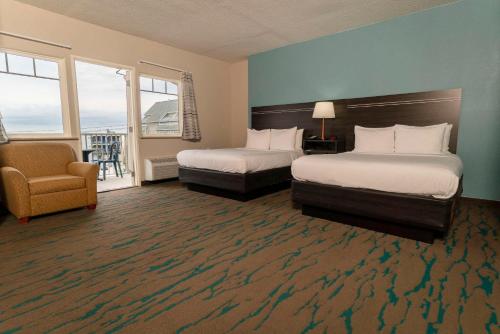 a hotel room with two beds and a chair at Gateway Hotel & Suites, an Ascend Collection Hotel in Ocean City