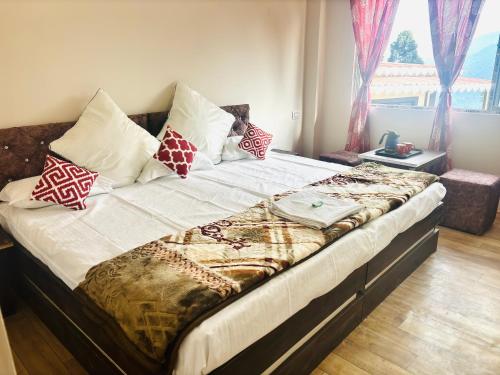 a large bed with pillows on it in a bedroom at Lava Hills Heaven Homestay in Lava