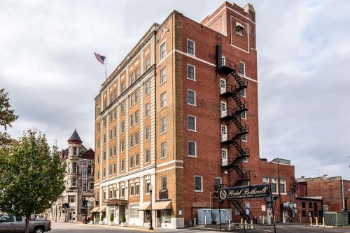 a tall brick building with a flag on top of it at Hotel Bothwell Sedalia Central District, an Ascend Collection Hotel in Sedalia