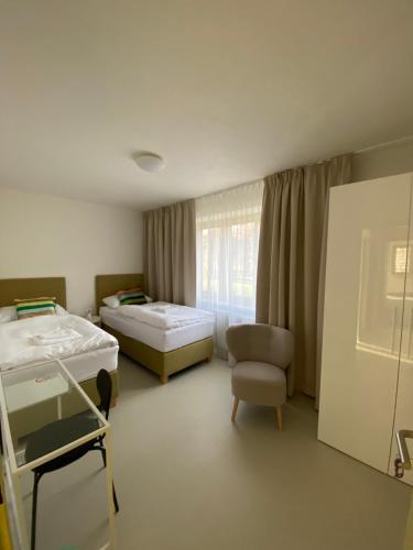 a hospital room with two beds and a chair at Turistická ubytovňa Stará škola Kokava in Kokava na Rimavica