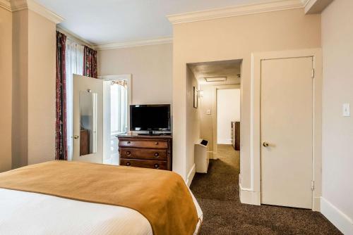 a bedroom with a bed and a flat screen tv at Hotel Bothwell Sedalia Central District, an Ascend Collection Hotel in Sedalia