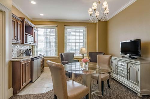 a kitchen and dining room with a glass table and chairs at Hotel Bothwell Sedalia Central District, an Ascend Collection Hotel in Sedalia
