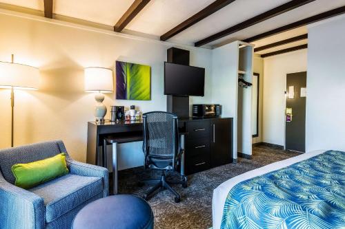a hotel room with a bed and a desk and a chair at Oasis Hotel and Conv Center, an Ascend Collection Hotel in Springfield