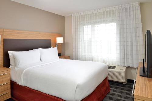 a bedroom with a large white bed and a window at TownePlace Suites by Marriott Raleigh Durham Airport Morrisville in Morrisville