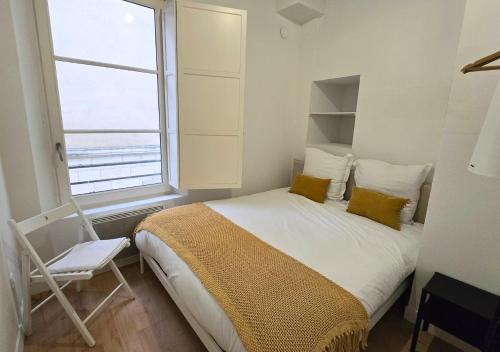une chambre avec un lit, une chaise et une fenêtre dans l'établissement L'Expérience Tourangelle #3, à Tours