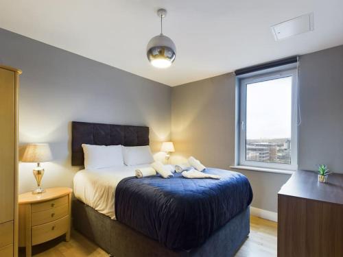 a bedroom with a bed with two towels on it at Stunning 2BR Apt in City Centre in Belfast