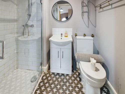 a bathroom with a toilet and a sink and a mirror at Stunning 2BR Apt in City Centre in Belfast
