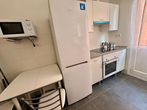 a small kitchen with a refrigerator and a microwave at Habitación centro Bilbao zona artística in Bilbao
