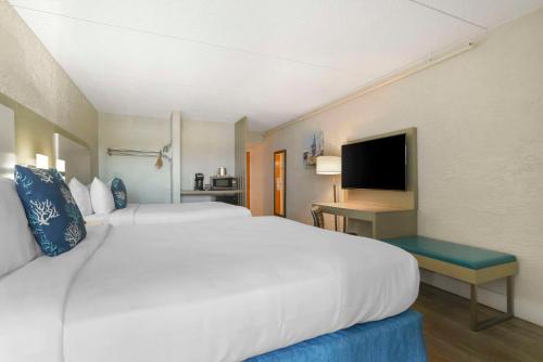 a hotel room with a large white bed and a television at Inn on Destin Harbor, an Ascend Collection Hotel in Destin