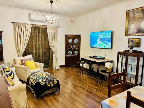 a living room with a table and a piano at XL Massive Art-Filled Home in Central Area, WALK to Sliema, St Julian's in Il-Gżira