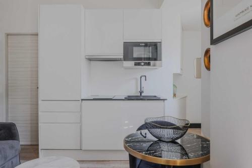 une petite cuisine avec une table et un micro-ondes dans l'établissement Charming Studio - 2P Courcelles, à Paris