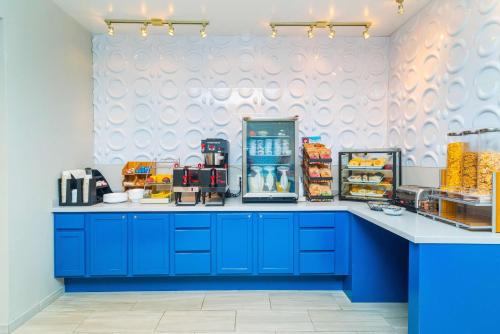 a kitchen with blue cabinets and a counter with food at Studio Z, an Ascend Collection Hotel in Saint Robert