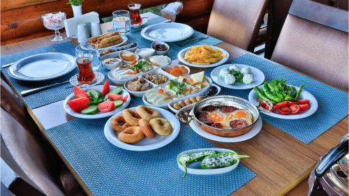 a table with plates and bowls of food on it at Sevgi Tepesi Bolu Panorama Otel in Bolu