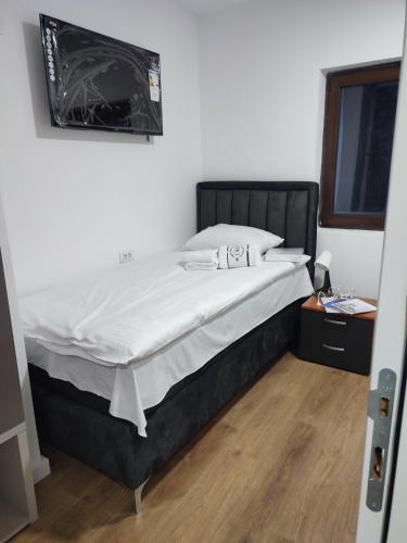 a bedroom with a large bed with white sheets at Vila Golijat in Raška