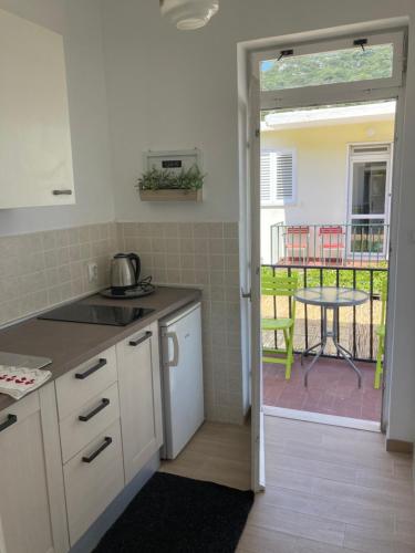 a kitchen with a view of a patio with a table at Apartments Paolo in Okuklje