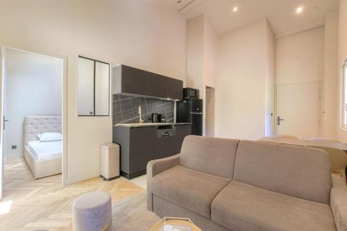 un salon avec un canapé et une cuisine dans l'établissement T2 neuf proche Lyon, St-Didier-au-Mont-d'Or, à Saint-Didier-au-Mont-dʼOr