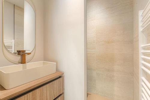 une salle de bain avec un lavabo et un miroir dans l'établissement T2 neuf proche Lyon, St-Didier-au-Mont-d'Or, à Saint-Didier-au-Mont-dʼOr