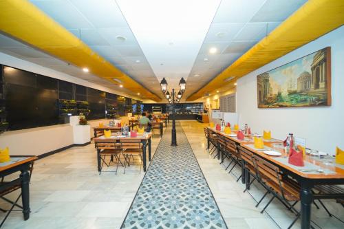 a dining room with tables and chairs in a restaurant at Zip by Spree Hotels Mangala International in Coimbatore