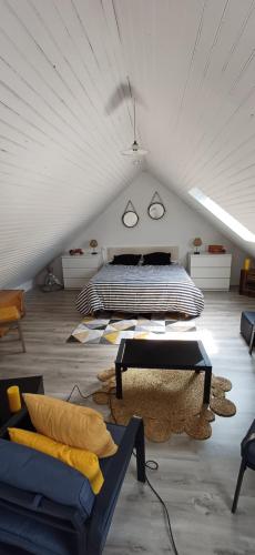 - une chambre mansardée avec un lit et un canapé dans l'établissement Gîte DA GOUSKET ROZ, à Trébeurden