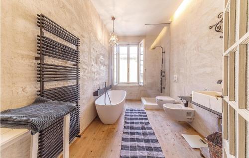 a bathroom with two sinks and a tub and two toilets at Casa Giu in Pacengo di Lazise