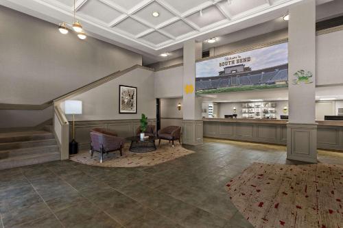 a lobby with a waiting area with chairs and a table at Wingate by Wyndham South Bend - Notre Dame in South Bend