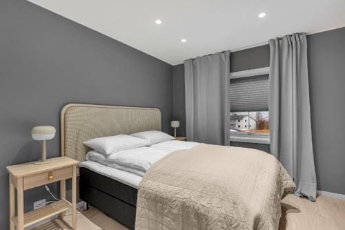 a bedroom with a bed and a window at Northstay - The Arctic Pearl, Central House with 4 bedrooms and 2 bathrooms in Tromsø