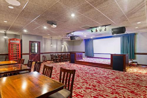 a large room with tables and chairs and a large screen at Wingate by Wyndham South Bend - Notre Dame in South Bend