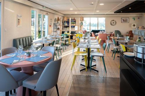 un restaurant avec des tables et des chaises dans une salle dans l'établissement Sure Hotel by Best Western Rochefort-sur-Mer, à Tonnay-Charente