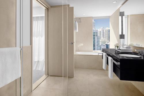 uma casa de banho com um lavatório e um chuveiro com uma janela em JW Marriott Hotel Marina no Dubai