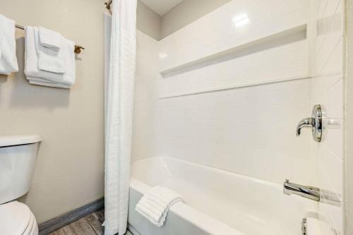 a white bathroom with a tub and a toilet at The Bradford Hotel, an Ascend Collection Hotel in Springfield