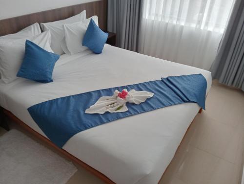 a bed with blue and white sheets and blue pillows at Highland Rhinor in Eldoret