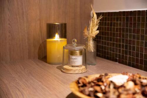 a candle and a plate of food on a table at Zenitude Hotel la Valadière, an Ascend Collection Hotel in Montpellier