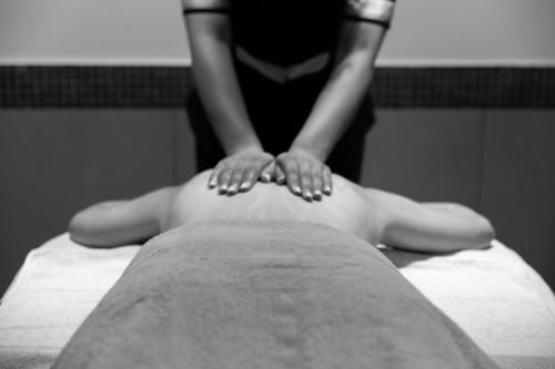 a woman sitting on a bed with her hands on top at Zenitude Hotel la Valadière, an Ascend Collection Hotel in Montpellier