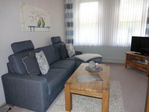 a living room with a blue couch and a coffee table at Ferienwohnung Strauß in Neuberend