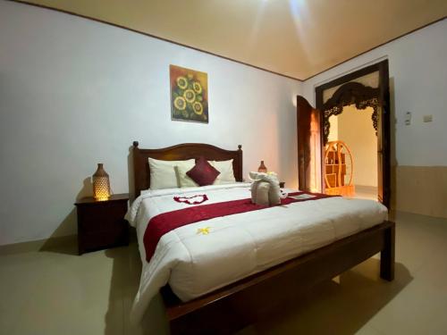 a bedroom with a bed with a teddy bear sitting on it at Mahesa House by SHM in Ubud