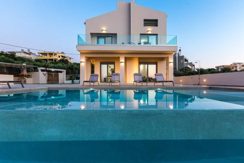 a house with a swimming pool in front of a house at Estel Residences in Chania Town