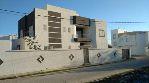 a building with a wall and a pole in front of it at Villa Romana Monastir in Monastir