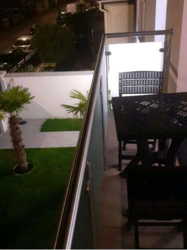 d'un balcon avec une table, une table et des chaises. dans l'établissement Love Room Charme, à Tremblay-en-France