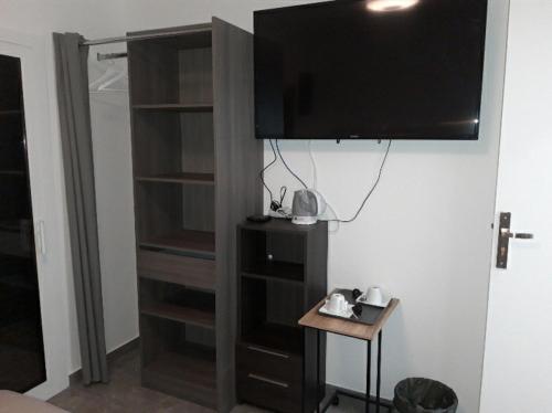 a room with a tv hanging on a wall at Love Room Charme in Tremblay En France