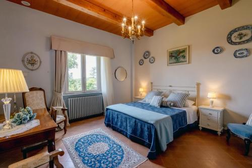 a bedroom with a bed and a desk and a window at Montelucci Chianti Agrivilla in Gaiole in Chianti