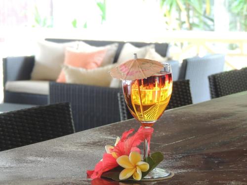 a glass of wine sitting on top of a table at Hotel La Roussette in Anse aux Pins
