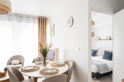 - une salle à manger avec une table, des chaises et un lit dans l'établissement Malouine - A 450m de la plage avec garage privatif, à Saint-Malo