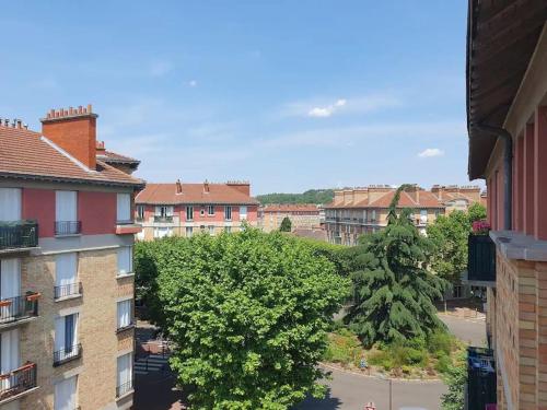 une vue d'une ville avec des bâtiments et des arbres dans l'établissement Appartement très lumineux à deux pas de Paris, à Suresnes